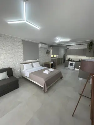 a bedroom with a large bed and a kitchen at AVR Airport Deluxe Suites 6 AIRPORT FREE SHUTLE in Markopoulo