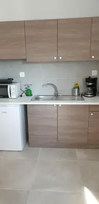 a kitchen with a sink and a microwave at AVR Airport Deluxe Suites 6 AIRPORT FREE SHUTLE in Markopoulo