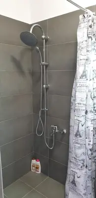 a shower with a shower curtain in a bathroom at AVR Airport Deluxe Suites 6 AIRPORT FREE SHUTLE in Markopoulo