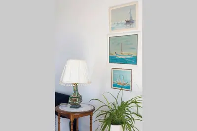 a living room with a lamp and pictures on the wall at Palmaya Villa, unique seafront experience in Vaia
