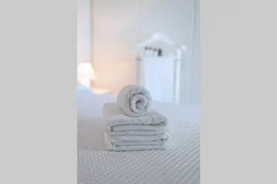 a room with a pile of towels on a bed at Palmaya Villa, unique seafront experience in Vaia