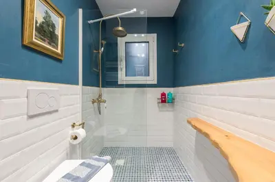 a bathroom with a toilet and a shower with blue walls at Chic and Comfort Home in Central Athens in Athens