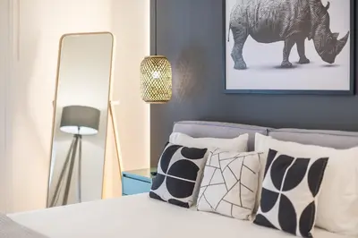a bedroom with a bed with a lamp and a picture of a zebra at Chic and Comfort Home in Central Athens in Athens