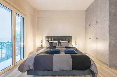 a bedroom with a large bed and a large window at Modern apartment Downtown Athens in Athens