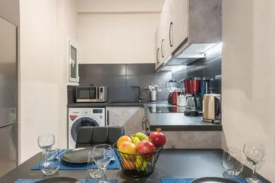 a kitchen with a bowl of fruit on a table at Modern apartment Downtown Athens in Athens