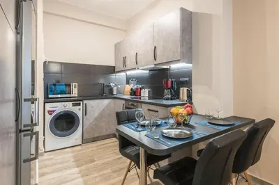 a kitchen with a table and chairs and a washer and dryer at Modern apartment Downtown Athens in Athens