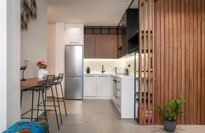 a kitchen with white cabinets and a stainless steel refrigerator at Glyfada Gallery Apartment by First Class Properties in Athens
