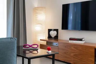 a living room with a tv and a table with scissors at Glyfada Gallery Apartment by First Class Properties in Athens