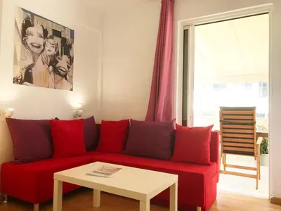 a red couch in a living room with a table at Athens by foot: Perfect flat with terrace in Athens