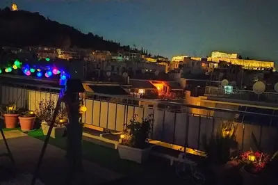 a view of a city from a balcony at night at Rooftop studio, Acropolis view! in Athens
