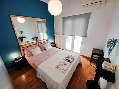 a bedroom with a large bed with a large mirror at Green tea balcony - quiet & cozy- Ano Glyfada in Athens