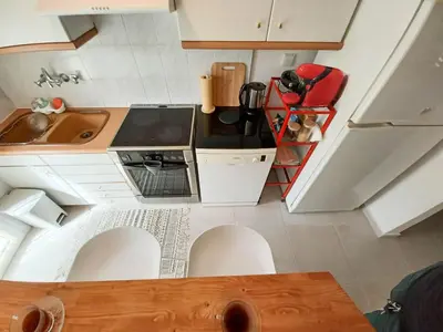 a small kitchen with white cabinets and a sink at Green tea balcony - quiet & cozy- Ano Glyfada in Athens