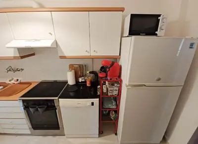 a small kitchen with a refrigerator and a microwave at Green tea balcony - quiet & cozy- Ano Glyfada in Athens