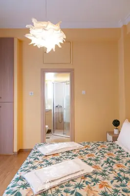 a bedroom with a bed and a chandelier at Acropolis Sweet House 3 in Athens