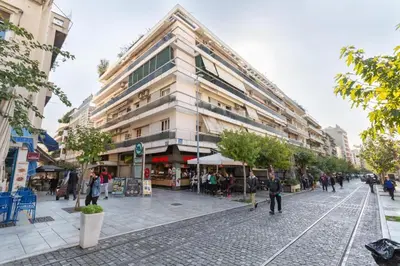 a large building on a street with people walking around it at Acropolis Sweet House 3 in Athens