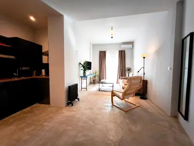 a living room with a couch and a chair in a room at Omega54 City Suites Athens Central Business District in Athens
