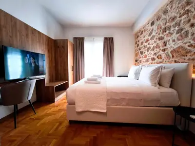 a hotel room with a bed and a television at Omega54 City Suites Athens Central Business District in Athens