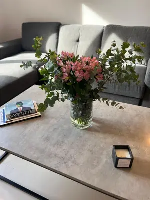 a vase with pink flowers on a coffee table at Omega54 City Suites Athens Central Business District in Athens