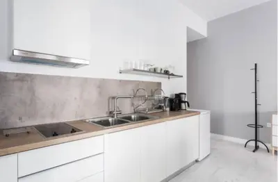 a kitchen with white cabinets and a sink at Dion Suites in Athens