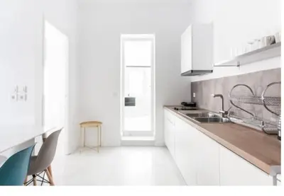 a white kitchen with a sink and a counter at Dion Suites in Athens