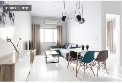 a living room with a couch and a table and chairs at Dion Suites in Athens