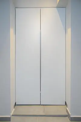 a pair of glass doors in a white wall at Athenian Stylish Living in Athens