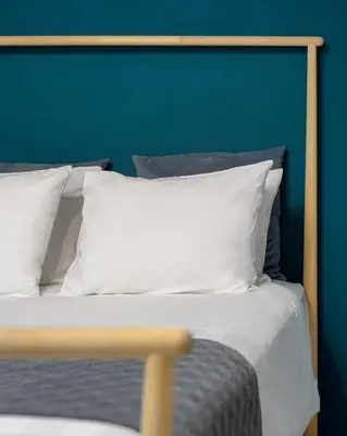 a bed with white pillows and a blue wall at Athenian Stylish Living in Athens