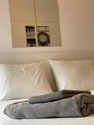 a bed with white pillows and a blanket on it at Olympic Hadrian Apartment next to Acropolis in Athens