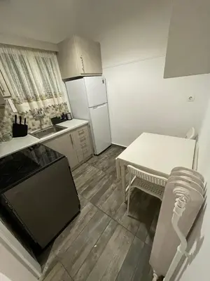 a small kitchen with a table and a refrigerator at Olympic Hadrian Apartment next to Acropolis in Athens