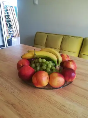 a plate of fruit on a wooden table at blue cielo sunny apartment in Palaiá Fókaia