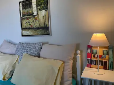 a bedroom with a bed and a table with a lamp at blue cielo sunny apartment in Palaiá Fókaia
