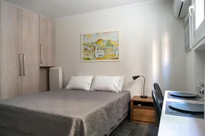 a small bedroom with a bed and a table at Pan's Cave Studio in Plaka in Athens