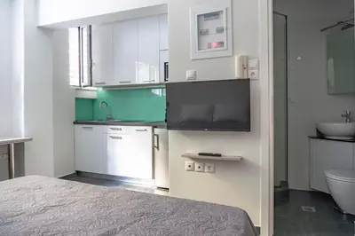 a bedroom with a bed and a sink and a bathroom at Pan's Cave Studio in Plaka in Athens
