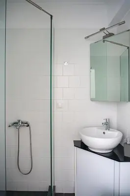 a bathroom with a sink and a glass shower at Pan's Cave Studio in Plaka in Athens