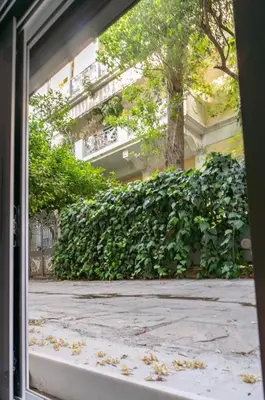 an open door of a building with a sidewalk at Pan's Cave Studio in Plaka in Athens