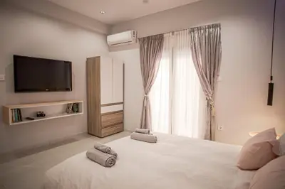 a bedroom with a large white bed with a flat screen tv at Luxury Apt 115m2 in Athens