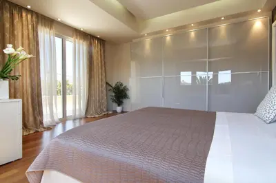 a bedroom with a large bed with glass walls at Villa Sabia in Vari