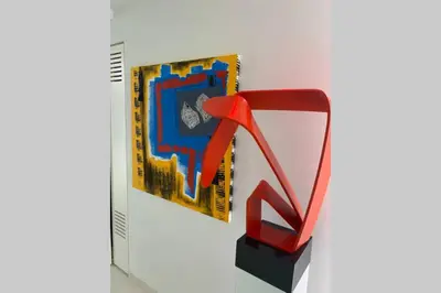 a book with a red object next to a painting at White Penthouse in Athens
