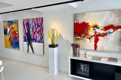 a living room with three paintings on the wall at White Penthouse in Athens