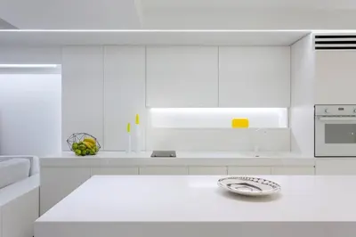 a white kitchen with white cabinets and a sink at White Penthouse in Athens