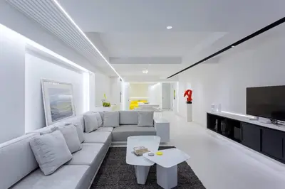 a white living room with a couch and a tv at White Penthouse in Athens