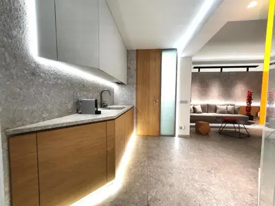 a kitchen with wooden cabinets and a couch in the background at Gray Studio in Athens