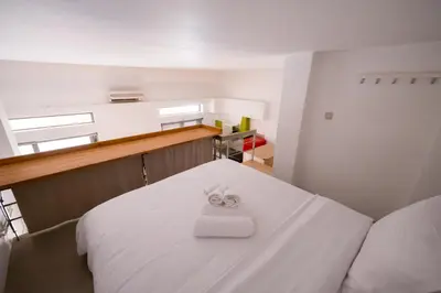 a room with a white bed with a towel on it at THISIO LOFT in Athens