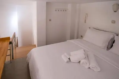 a bedroom with a white bed with towels on it at THISIO LOFT in Athens