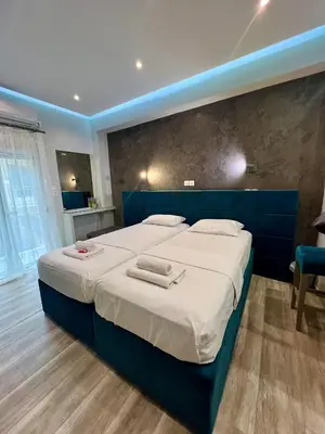 a bedroom with a large bed with a blue headboard at Emerald Lux Apartment in Athens