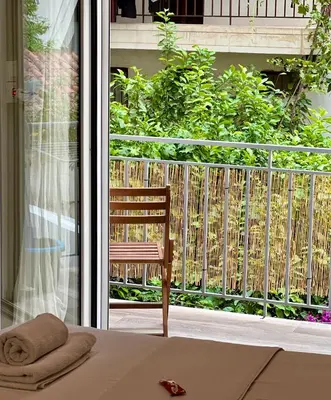 a chair sitting on a bed in front of a window at Emerald Lux Apartment in Athens