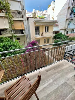 a wooden bench sitting on top of a balcony at Emerald Lux Apartment in Athens