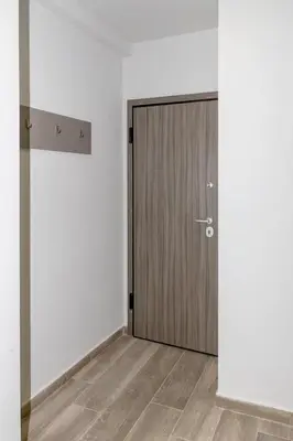 a wooden door in a white room with a wooden floor at Emerald Lux Apartment in Athens
