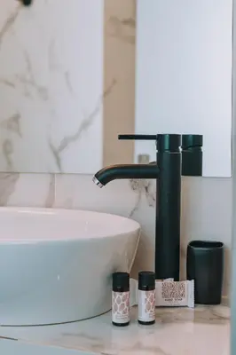 a bathroom counter with a sink and two cups at IVY Apartments in the Heart of Athens in Athens