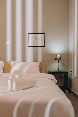 a bedroom with two beds with white sheets and a lamp at IVY Apartments in the Heart of Athens in Athens